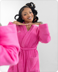 GloRilla in a pink outfit with hair rollers